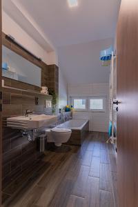 ein Badezimmer mit zwei Waschbecken, einer Badewanne und einem Spiegel in der Unterkunft APARTMÁNY POD SJEZDOVKOU in Abertamy
