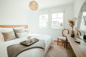 a bedroom with a bed and a desk with a tray on it at La Clé de Quentovic ◎ Duplex de 150 m2 ◎ Standing in Le Touquet-Paris-Plage