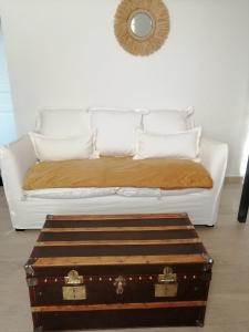 een wit bed met een witte bank en een kofferbak bij Zofia appartements - Duplex avec terrasse #2 in Moustiers-Sainte-Marie