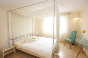 1 dormitorio con cama con dosel y silla azul en Hôtel Bellevue en Porrentruy