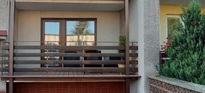 una panca di legno seduta sul lato di una casa di Max a Liptovský Mikuláš