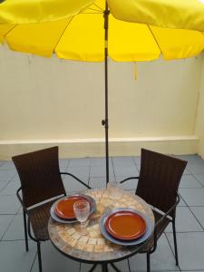 einen Tisch mit 2 Stühlen und einem Sonnenschirm in der Unterkunft Cozy Central 3 Bedrooms Bragas in Porto