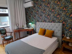 ein Schlafzimmer mit einem Bett mit gelben Kissen und einer Tapete in der Unterkunft Cozy Central 3 Bedrooms Bragas in Porto