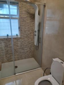 ein Bad mit Dusche, WC und Fenster in der Unterkunft Cozy Central 3 Bedrooms Bragas in Porto