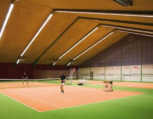 two people are playing tennis on a tennis court at Gasthaus-Pension Islekhöhe Gansen in Krautscheid