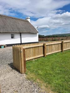 a wooden fence in front of a house at Ballymultimber Cottages in Limavady