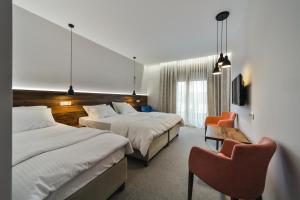 a hotel room with two beds and a chair at Hotel Vladimir in Budva