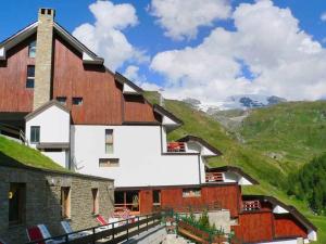 a building on a hill with chairs in front of it at Cervinia Due in Breuil-Cervinia