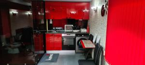 a red kitchen with red cabinets and a stove at Casa De Cristal in Sofia
