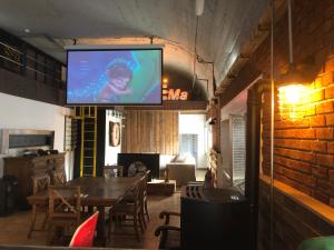 a living room with a table and a television on a wall at APPARTEMENT style loft industrielle de 250m2 in Longwy