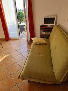 a couch sitting in a living room with a computer at Apartments Helena in Umag