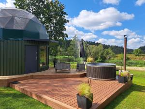 a deck with a hot tub and a gazebo at Šventosios Slėnis in Grikiapeliai
