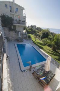 a swimming pool with two chairs and a house at Villa Sveta in Petrovac na Moru
