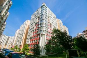 a tall apartment building with red and white at Apartament spatios in complex residential in Chişinău