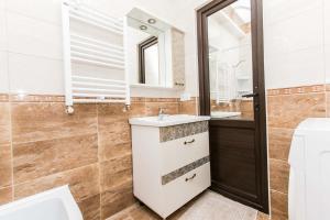 a bathroom with a sink and a mirror at Apartament spatios in complex residential in Chişinău