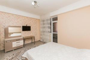 a bedroom with a bed and a tv on a wall at Apartament spatios in complex residential in Chişinău