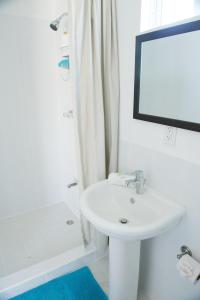 Baño blanco con lavabo y espejo en Cosmopolitan Guesthouse en Hopkins
