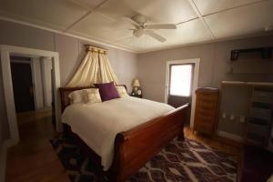 um quarto com uma cama e uma ventoinha de tecto em Plum Crooked Poets Cottage - Walk to Town - Luxury King Bed - Near Asheville - Excellent Wi-Fi em Marshall