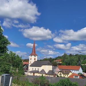a large white church with a steeple in a town at Riccis 47m2 bamboo flat in Grosspertholz