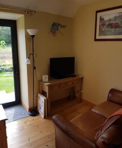 a living room with a couch and a television at Jakels Rest in Lairg