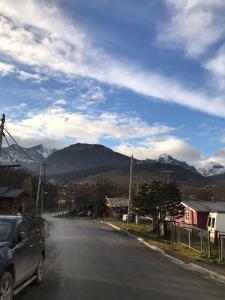 a car driving down a street with mountains in the background at Departamento Pájaro Carpintero in Ushuaia
