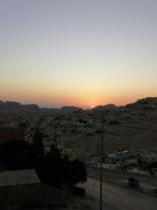 a view of a city with the sunset in the background at Petra paradise home in Wadi Musa