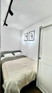 a bedroom with a bed and two pictures on the wall at Apartament 21 (1) in Szczyrk