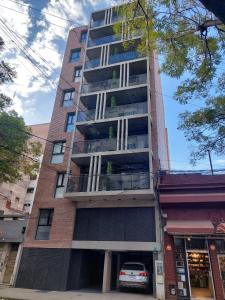 un grand bâtiment avec une voiture garée devant dans l'établissement Alquiler Temporario Rosario 3, à Rosario