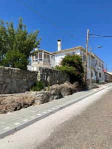 uma rua vazia com uma casa e uma parede de pedra em Villa Entre Encinas em Moralina