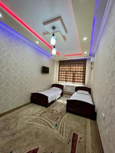 2 camas en una habitación con luces moradas en Samarkand luxury apartment #2, en Samarkand