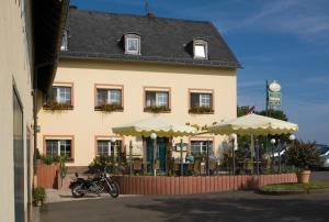 a building with a motorcycle parked in front of it at Gasthaus-Pension Islekhöhe Gansen in Krautscheid