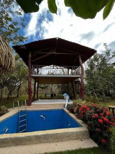 a swimming pool with a pavilion in a park at Casa vacacional Brisas del Mar in San Juanillo