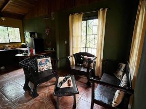 sala de estar con 2 sillas y mesa en Casa vacacional Brisas del Mar, en San Juanillo