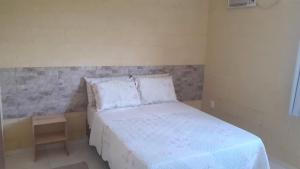 a small bedroom with a bed and a night stand at Flat do Sossego 1 in Triunfo +20 photos