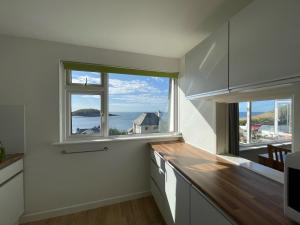 a kitchen with a large window with a view of the ocean at Sea Spirit - Sweeping Sea Views first floor spacious modern apartment in Looe- with FREE parking! in Looe