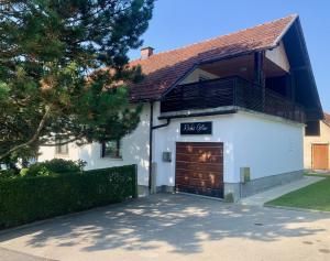 a white house with a large garage at Rooms Optim in Ptuj