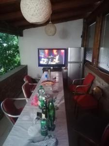 a dining room with a long table and a tv at Sphinx Apartment in Visoko
