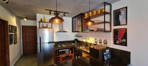 a kitchen with a stainless steel refrigerator and cabinets at Brisas do Amor Apto 109 in Pipa