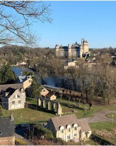 a castle on a hill with houses and a lake at 5 pièces familiales in Trosly-Breuil