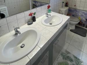 bagno con 2 lavandini e servizi igienici di Colibri de la Pointe a Le Robert