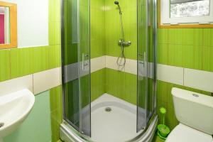 a green tiled bathroom with a shower and a sink at Bungalow close to the beach Sianozety in Sianozety