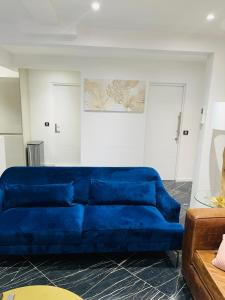 een blauwe bank in een woonkamer bij APPARTEMENT AVEC VUE SUR LA TOUR EIIFEL in Issy-les-Moulineaux