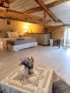 a bedroom with two beds and a table with flowers on it at o le zen in Saint-Juire-Champgillon