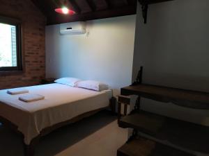 1 dormitorio con 1 cama con 2 toallas en Amanita Rosa, en Praia do Rosa