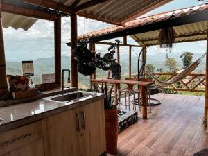 a kitchen with a sink and a table on a deck at Poema Glamping in Palestina