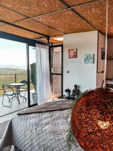 a room with a bed and a balcony with a table at Poema Glamping in Palestina