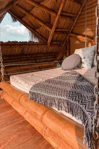 a swing bed in a room with a wooden floor at Poema Glamping in Palestina
