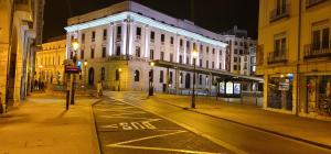 eine Stadtstraße in der Nacht mit einem weißen Gebäude in der Unterkunft Mía Suites II Loft Centro Histórico - PARKING & WIFI FREE in Burgos