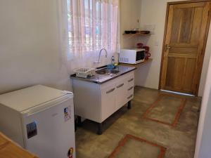 eine kleine Küche mit Spüle und Kühlschrank in der Unterkunft San Nicolas Residêncial in São Bento do Sapucaí