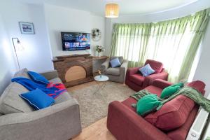 sala de estar con 2 sofás y chimenea en Beautiful 4 bedroom house with free parking Luton en Luton